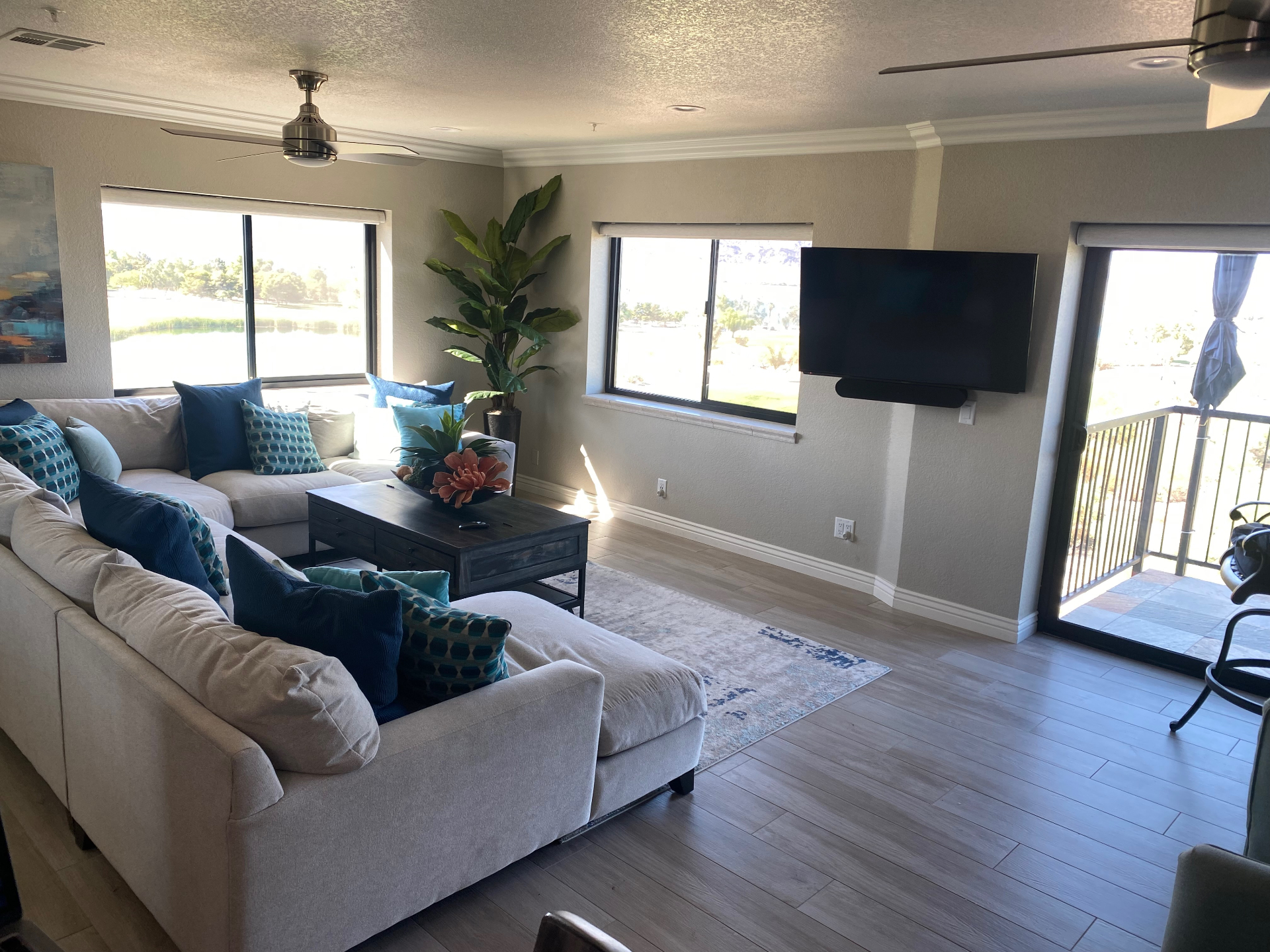 Living room sectional with mounted TV and balcony access