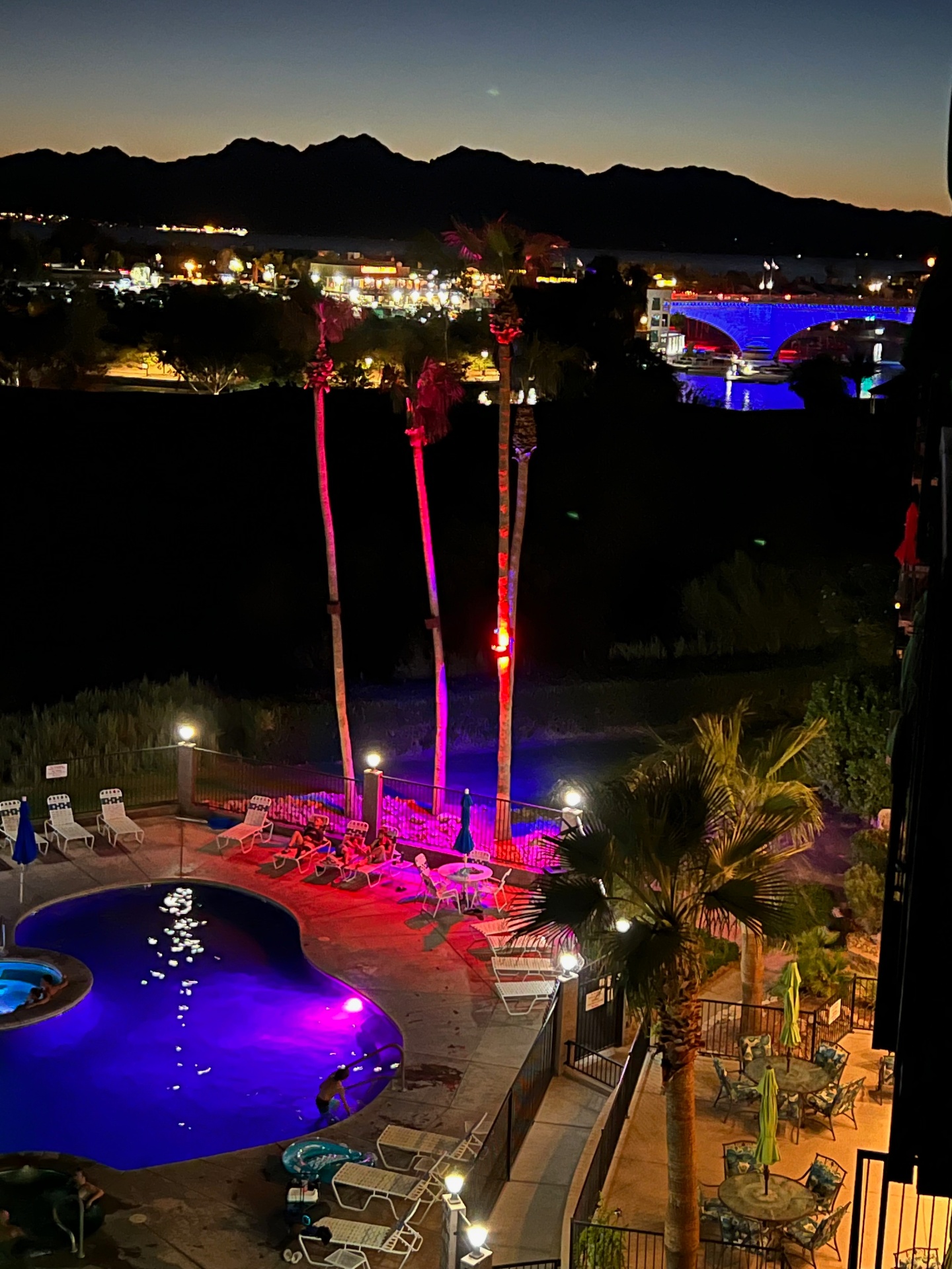 Resort pool and London Bridge at night